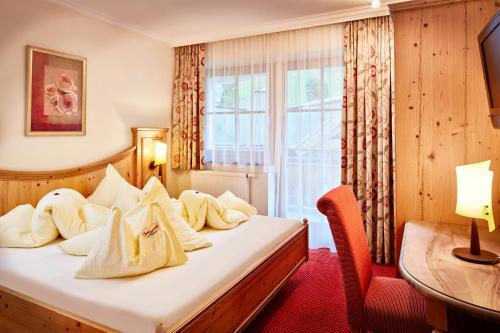a hotel room with a bed and a window at Bauernhof Hotel Oberschwarzach in Saalbach Hinterglemm