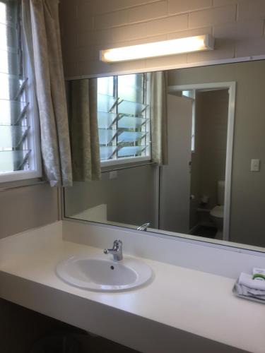a bathroom with a sink and a mirror at Paradise Motel in Mackay