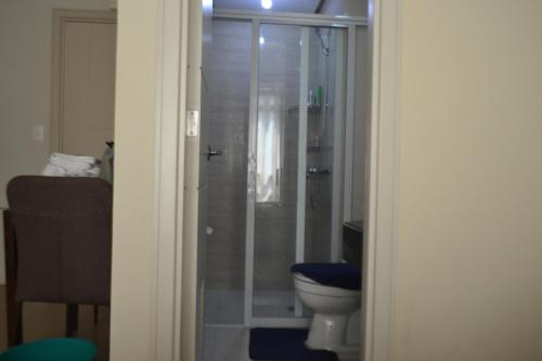 a bathroom with a toilet and a glass shower at Daichi Place Newport Boulevard in Manila