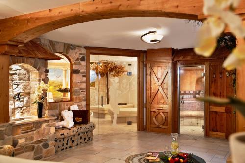 a room with a stone fireplace and a walk in shower at Bauernhof Hotel Oberschwarzach in Saalbach Hinterglemm