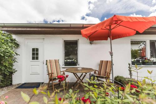 eine Terrasse mit einem Tisch, Stühlen und einem Sonnenschirm in der Unterkunft Ferienwohnungen in ruhiger Ortsran in Lauterbach