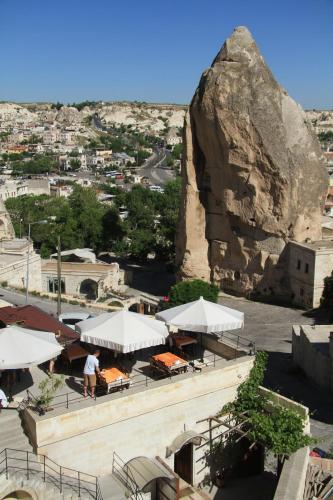 a building with white umbrellas and a large rock at Vezir Cave Suites in Goreme