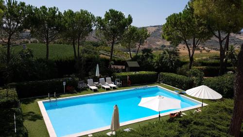 a swimming pool with chairs and umbrellas next to it at Villa Vittoria in Citta' Sant'Angelo