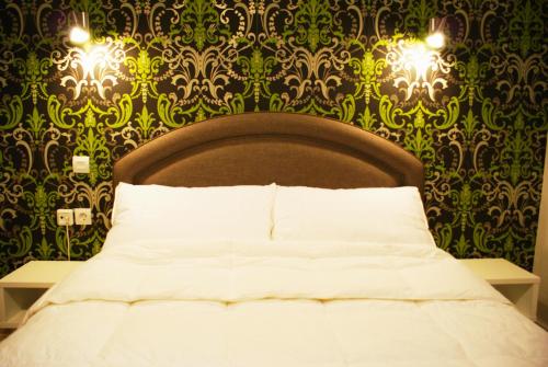 a bedroom with a bed and a green and gold wallpaper at Doviros Hotel in Doirani