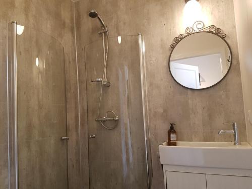 uma casa de banho com um chuveiro, um lavatório e um espelho. em Bólstaðarhlíð Guesthouse em Bólstaðarhlíð