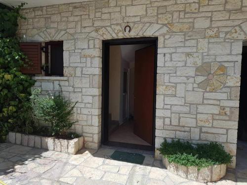 a stone building with a door in the middle at Eglent's tourist house in Sarandë