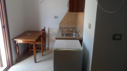 a small kitchen with a sink and a table at Eglent's tourist house in Sarandë
