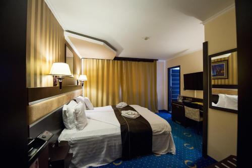 a hotel room with a bed and a mirror at Grand Hotel Hebar in Pazardzhik