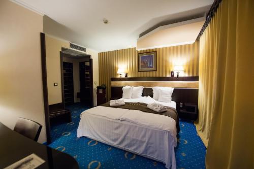 a bedroom with a large bed in a room at Grand Hotel Hebar in Pazardzhik