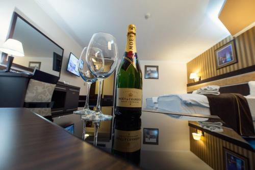 a bottle of wine and a wine glass on a table at Grand Hotel Hebar in Pazardzhik