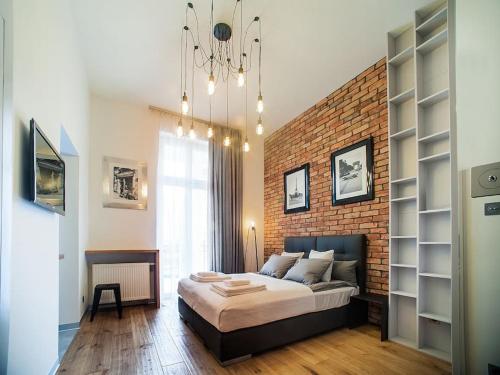 - une chambre avec un grand lit et un mur en briques dans l'établissement Swiety 7, à Poznań
