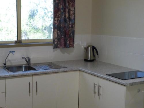 um balcão de cozinha com um lavatório e uma janela em Watervale Retreat em Watervale