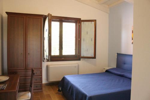 ブゼート・パリッツォーロにあるCasa Vacanze Al Basytaのベッドルーム(青いベッド1台、窓付)