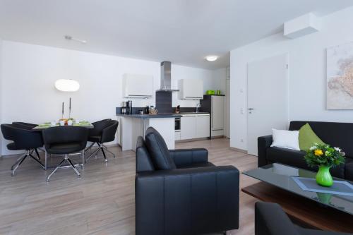 a living room with a couch and chairs and a table at DünenResort in Binz, strandnahe und moderne FeWos mit Balkon, teilweise mit Meerblick, in Binz