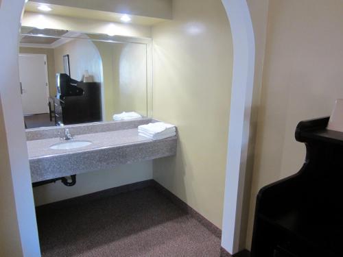 a bathroom with a sink and a large mirror at El Rancho Inn in Hawthorne