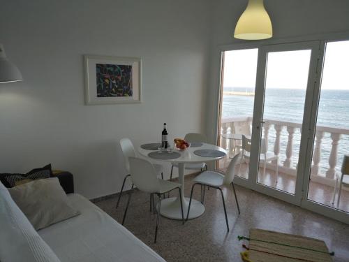 a bedroom with a table and chairs with a view of the ocean at Apartamentos Rocamar el Medano in El Médano