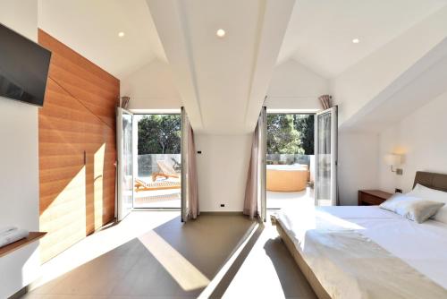 a bedroom with a large bed and large windows at Chiponsky One - 5 star beachfront property in Bol