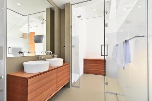 a bathroom with two sinks and a glass shower at Chiponsky One - 5 star beachfront property in Bol