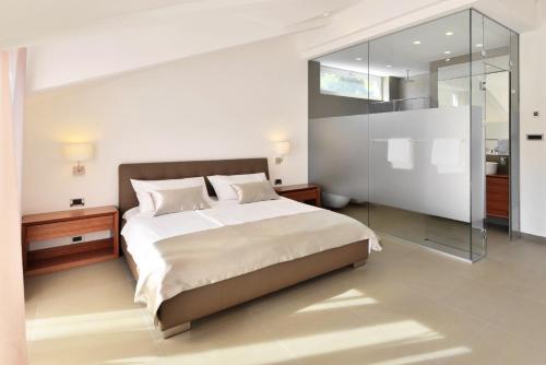 a bedroom with a large bed and a glass wall at Chiponsky One - 5 star beachfront property in Bol