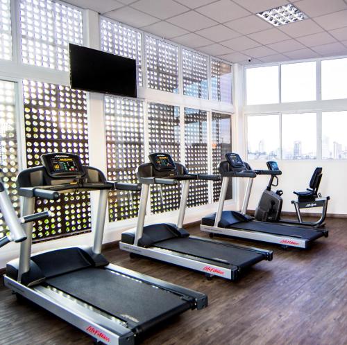 a gym with several tread machines and a flat screen tv at ibis Jundiai Shopping in Jundiaí