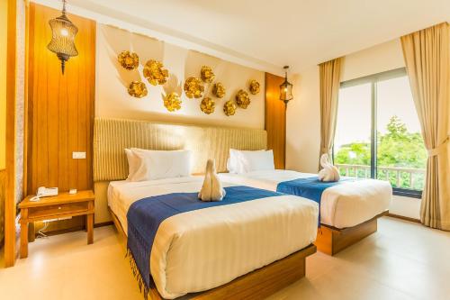 Een bed of bedden in een kamer bij The Signature Hotel @ Thapae