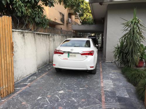 a white car parked in a parking lot at Star House in Islamabad