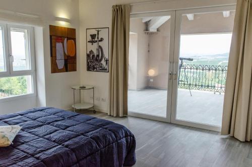 une chambre avec un lit et une porte coulissante en verre dans l'établissement Langhe Apartment - Mondovì, à Mondovi