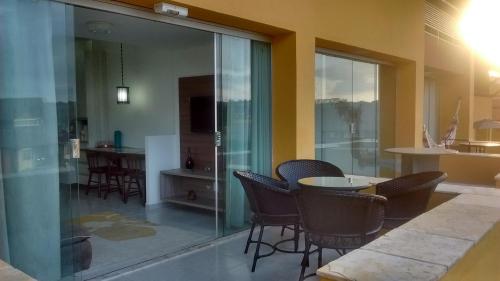 a room with chairs and a table and a glass wall at Winterville Flats Gravatá in Gravatá