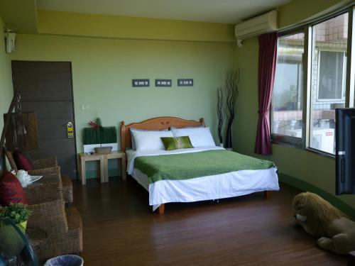 a bedroom with a bed in a green room at Da-Tong Vacation Hotel in Chenggong