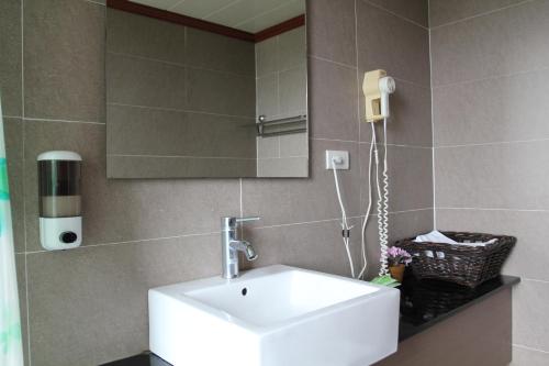 ein Badezimmer mit einem weißen Waschbecken und einem Spiegel in der Unterkunft Da-Tong Vacation Hotel in Chenggong