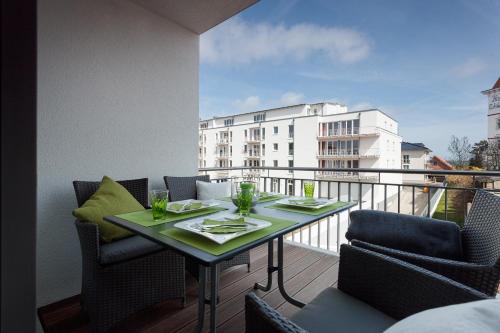 a table on a balcony with a view of a building at DünenResort Ostseebad Binz in Binz