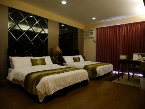 a hotel room with two beds and a piano at Da-Tong Vacation Hotel in Chenggong