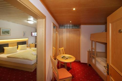 a small room with a bed and a bunk bed at Altachhof Hotel und Ferienanlage - Jokercard im Sommer inklusive in Saalbach Hinterglemm
