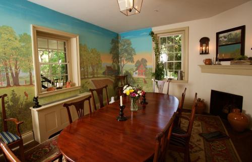 uma sala de jantar com uma mesa de madeira com flores em The Zevely Inn em Winston-Salem