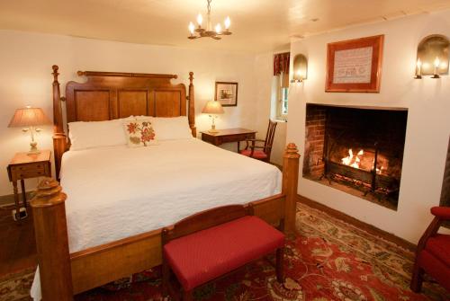 um quarto com uma cama e uma lareira em The Zevely Inn em Winston-Salem