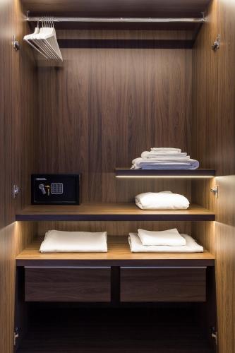 a wooden shelf with white pillows on it at Rhome Suites in Rome