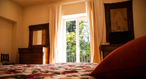 a bedroom with a bed and a large window at B&B La Villa in Giardini Naxos