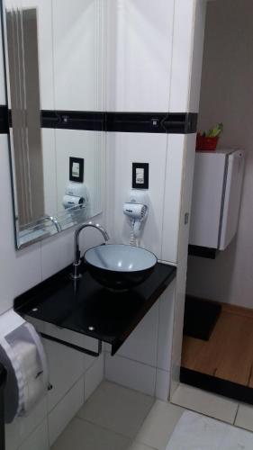 a bathroom with a black counter with a sink at Center Park Hotel Lapa in Sao Paulo