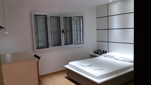 サンパウロにあるCenter Park Hotel Lapaのベッドと机と窓のある寝室