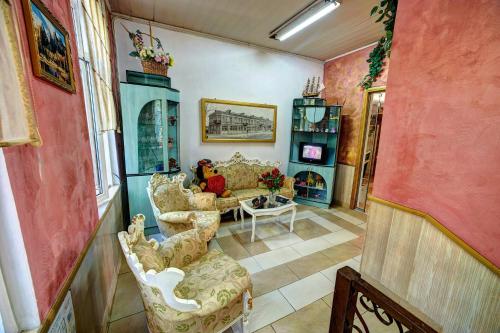 a living room with a couch and a table and chairs at Hotel Izvora in Ruse