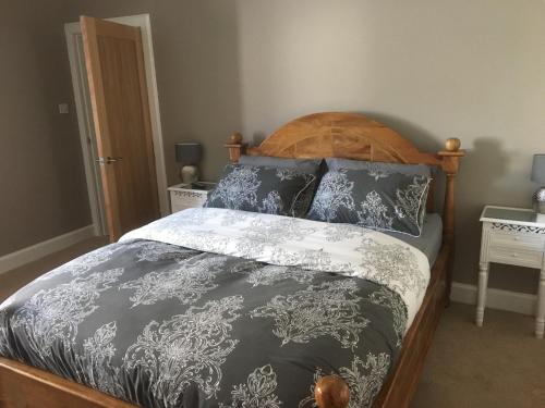 uma cama com lençóis e almofadas preto e branco em 1 St Ellas House Apartment em Eyemouth