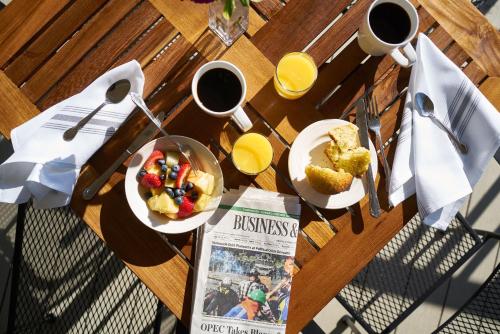 a table with two plates of breakfast food and a newspaper at Higgins Beach Inn in Scarborough