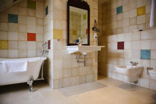 Un baño con lavabo, bañera e inodoro. en Savoia Castle, en Škvorec