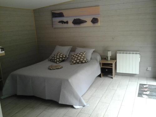 a bedroom with a bed with two pillows on it at Les nids des falaises in Saint-Jouin-Bruneval