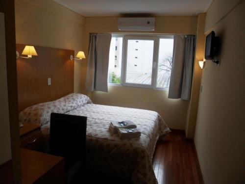 a hotel room with a bed and a window at Hotel Juramento in Buenos Aires