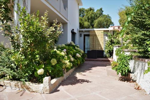a house with a garden of flowers and a walkway at B&B Gianni e Pia in Luogosanto