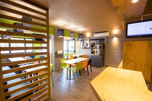 une salle à manger avec une table et une cuisine dans l'établissement ibis budget Narbonne Est, à Narbonne