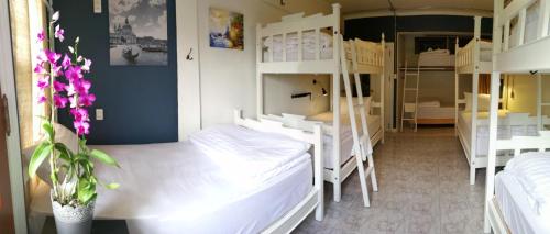 a dorm room with two beds and two tables at Bed in Town in Chiang Mai