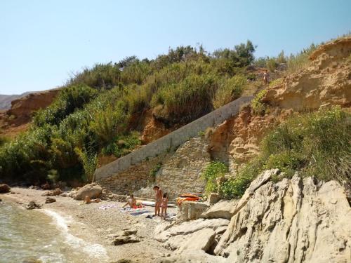 a group of people on a beach near the water at Villa PANORAMA in Pag