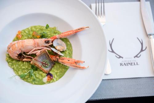 a plate of food with a lobster on a green sauce at Rainell Dolomites Retreat in Ortisei